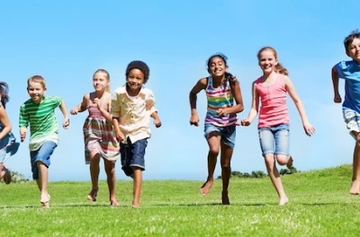 seven kids running on a field