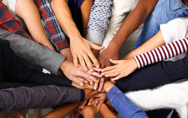 Group of hands holding together in the centre