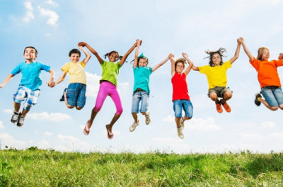 Kids holding hands jumping in air