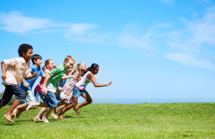 Seven kids sprinting on a green field - fair chance for all inquiry main image